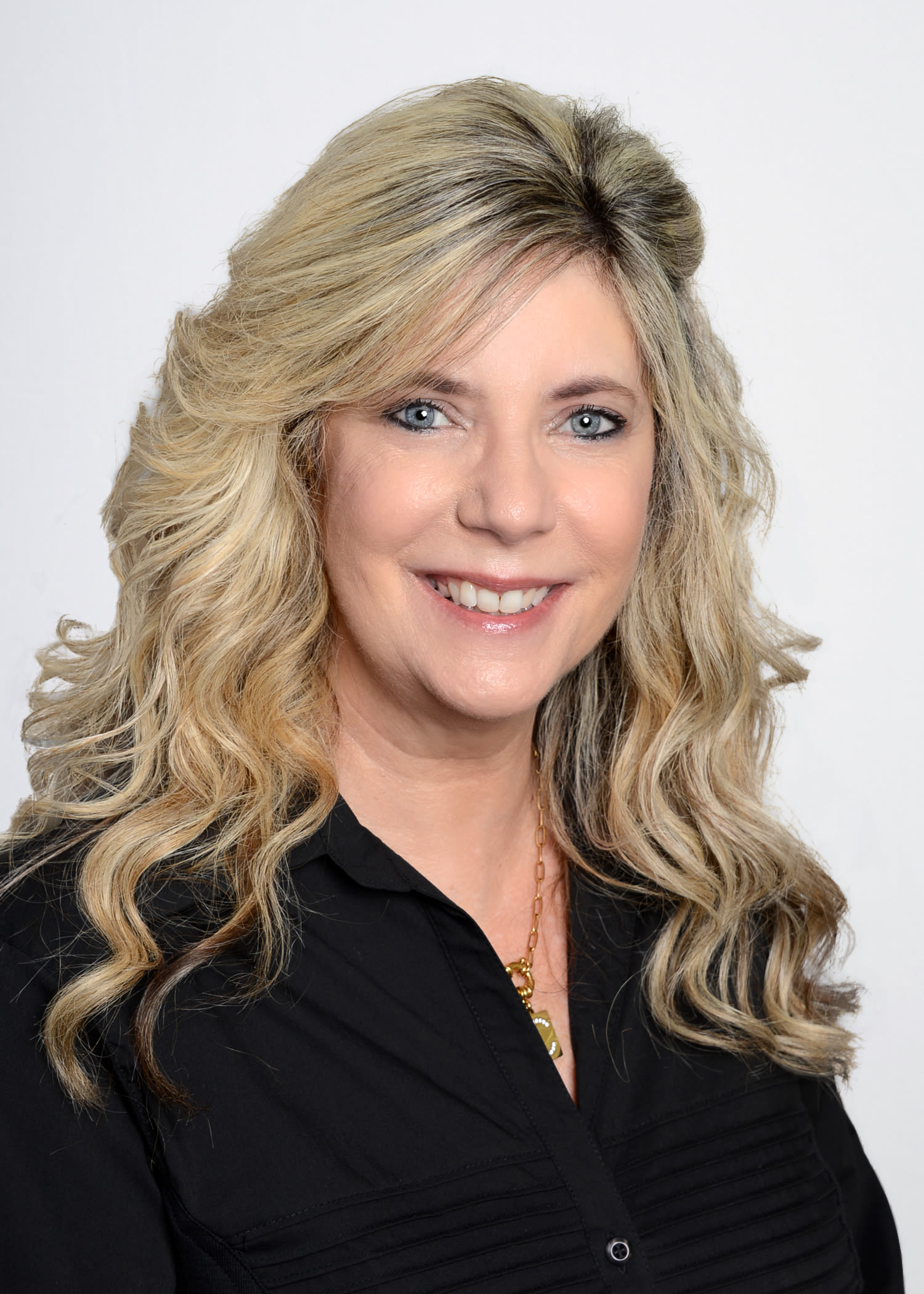 Professional headshot of smiling blonde woman in black blouse