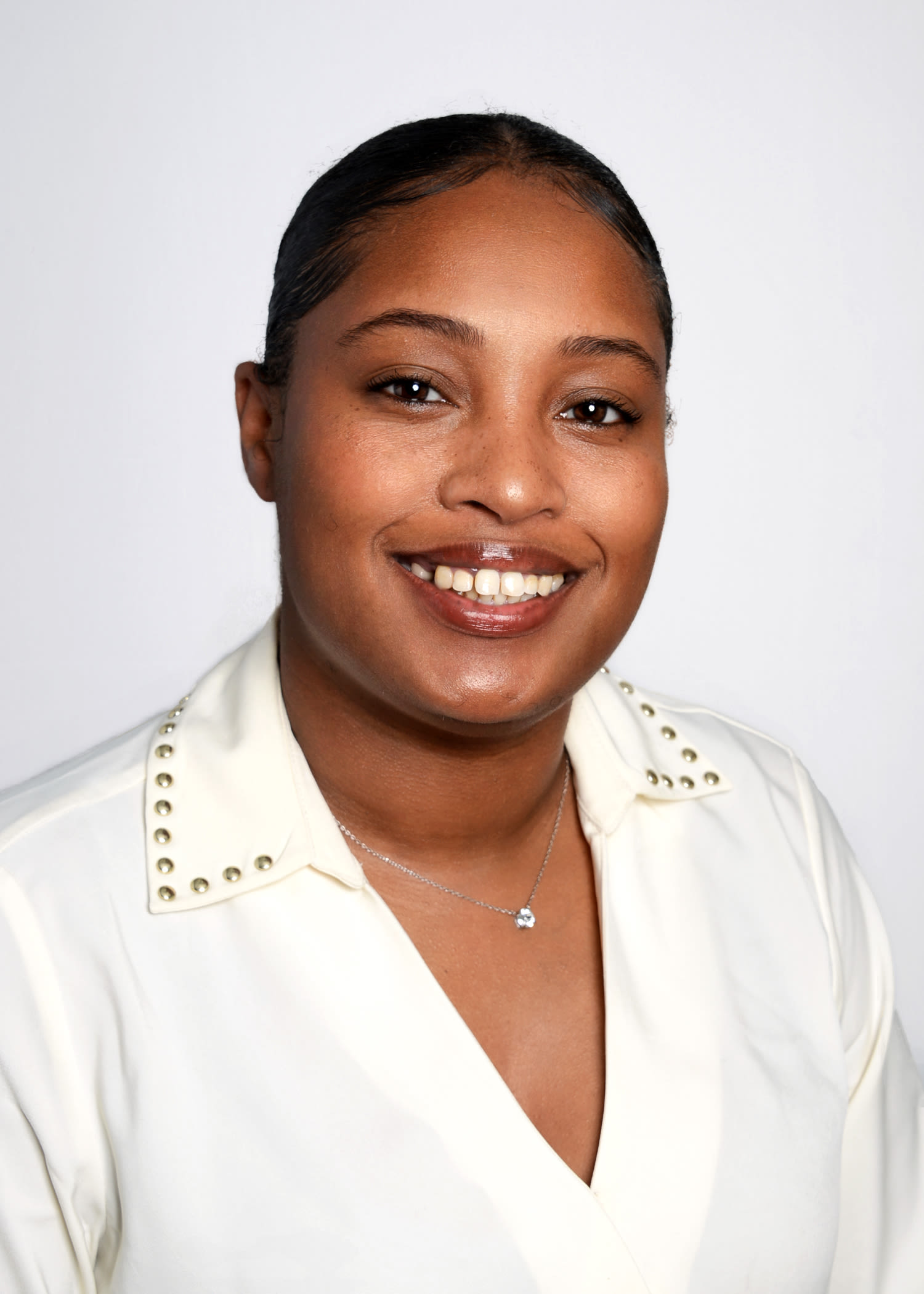 Professional headshot of smiling woman in white blouse