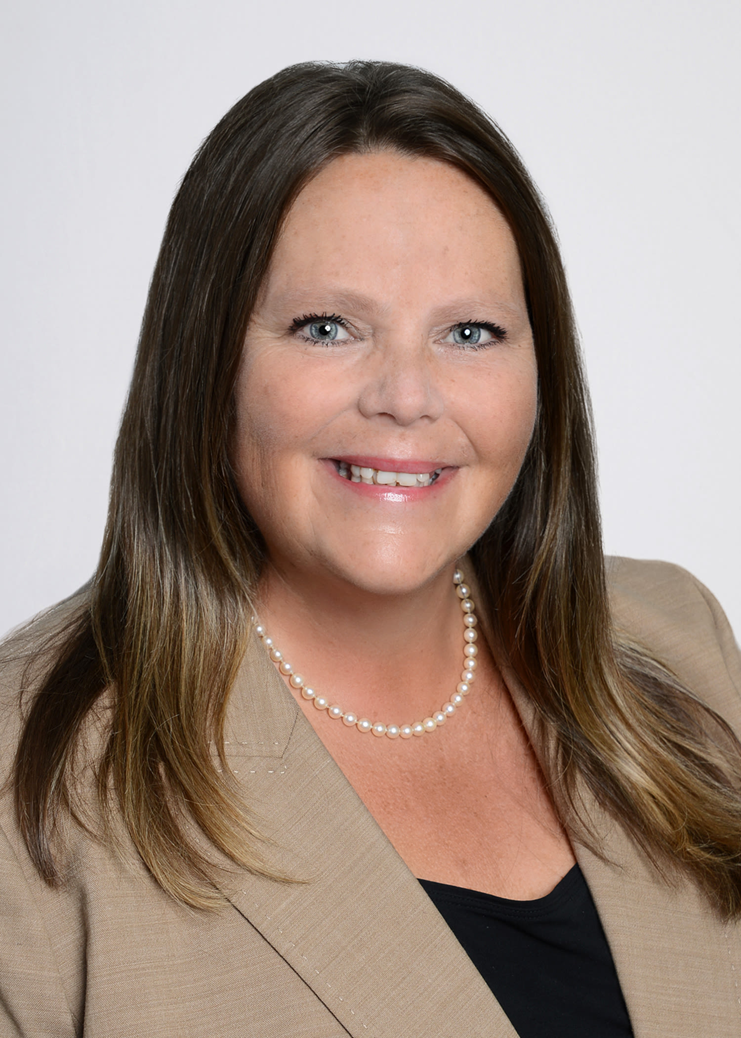 Professional headshot of woman in beige blazer