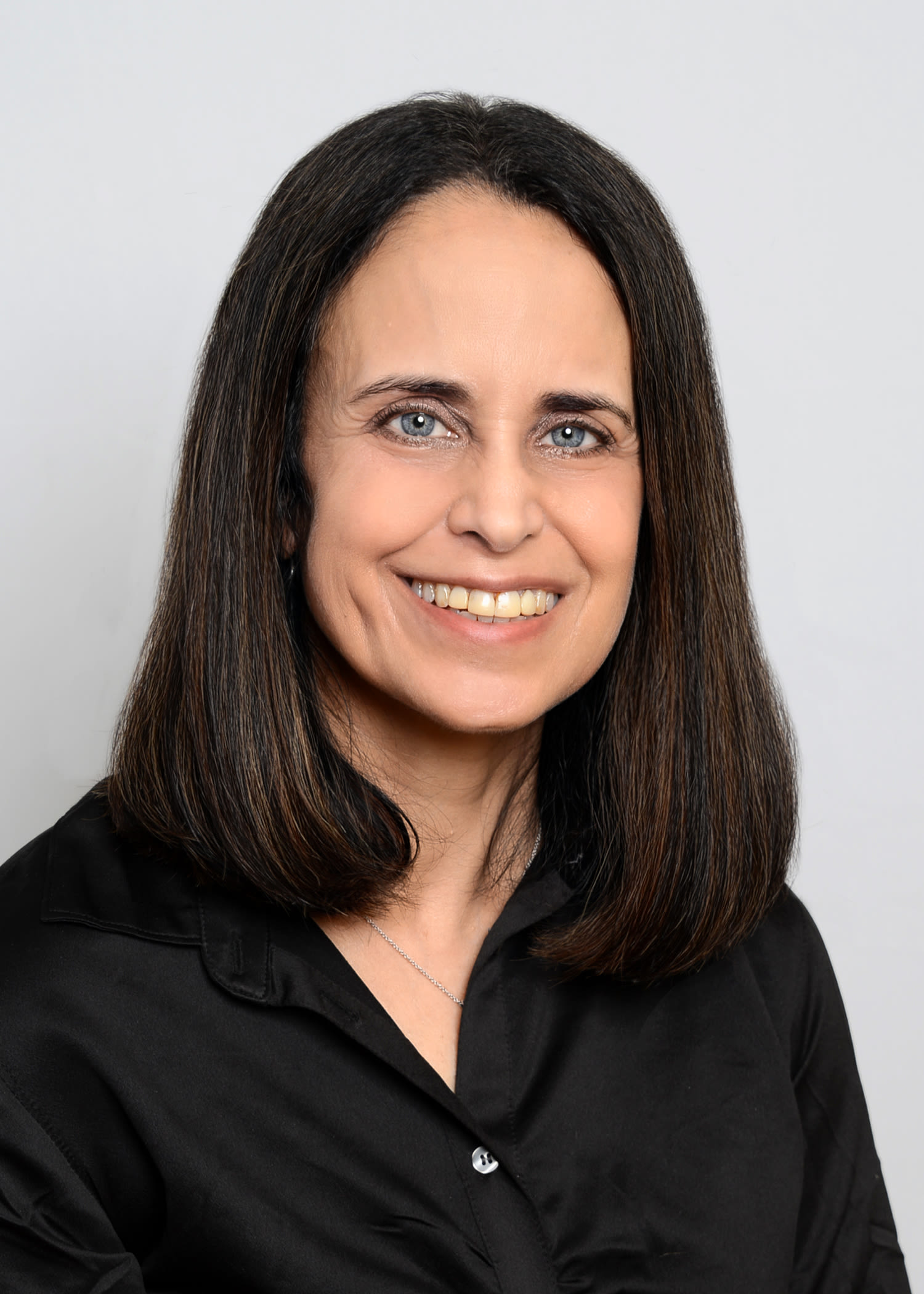 Professional headshot of smiling woman with dark hair