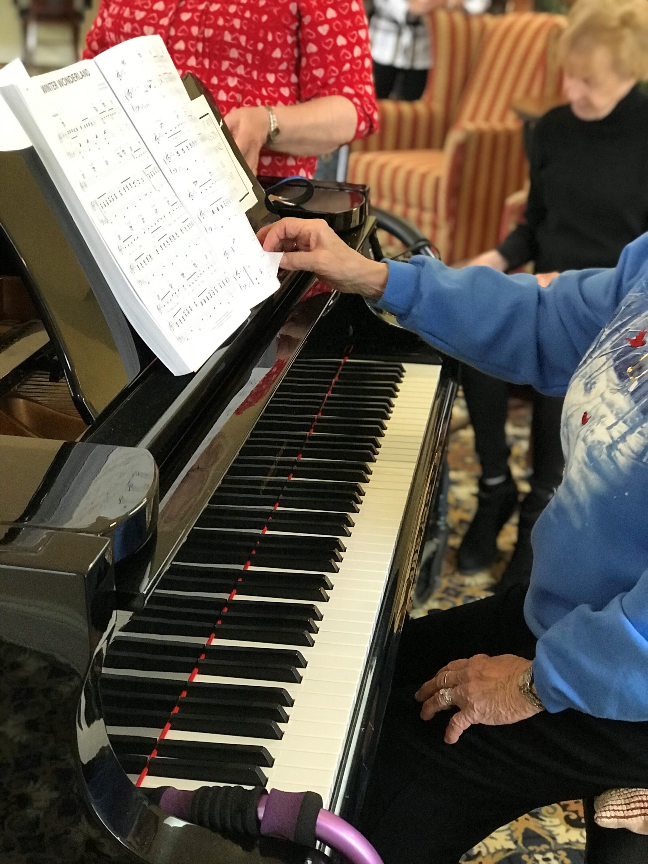 Seniors playing piano with sheet music