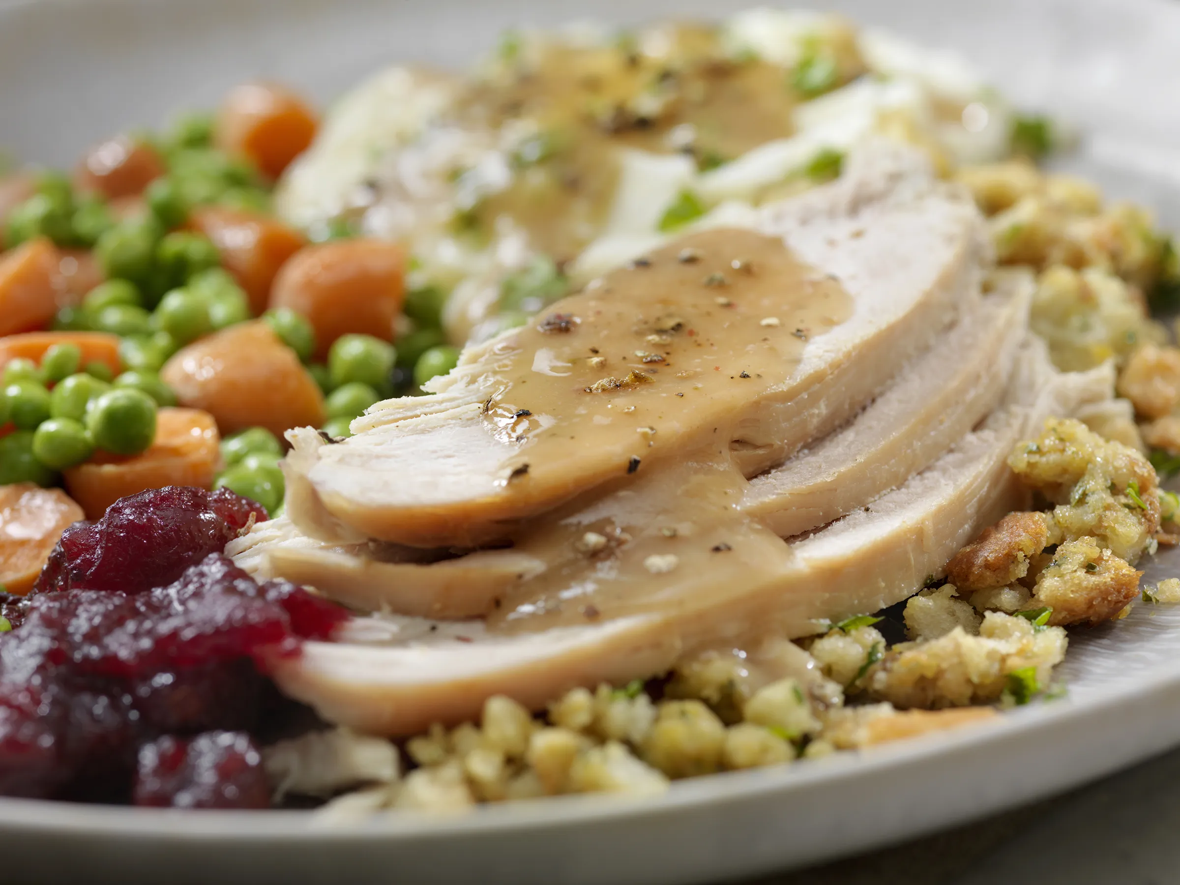 Sliced turkey with gravy and holiday sides