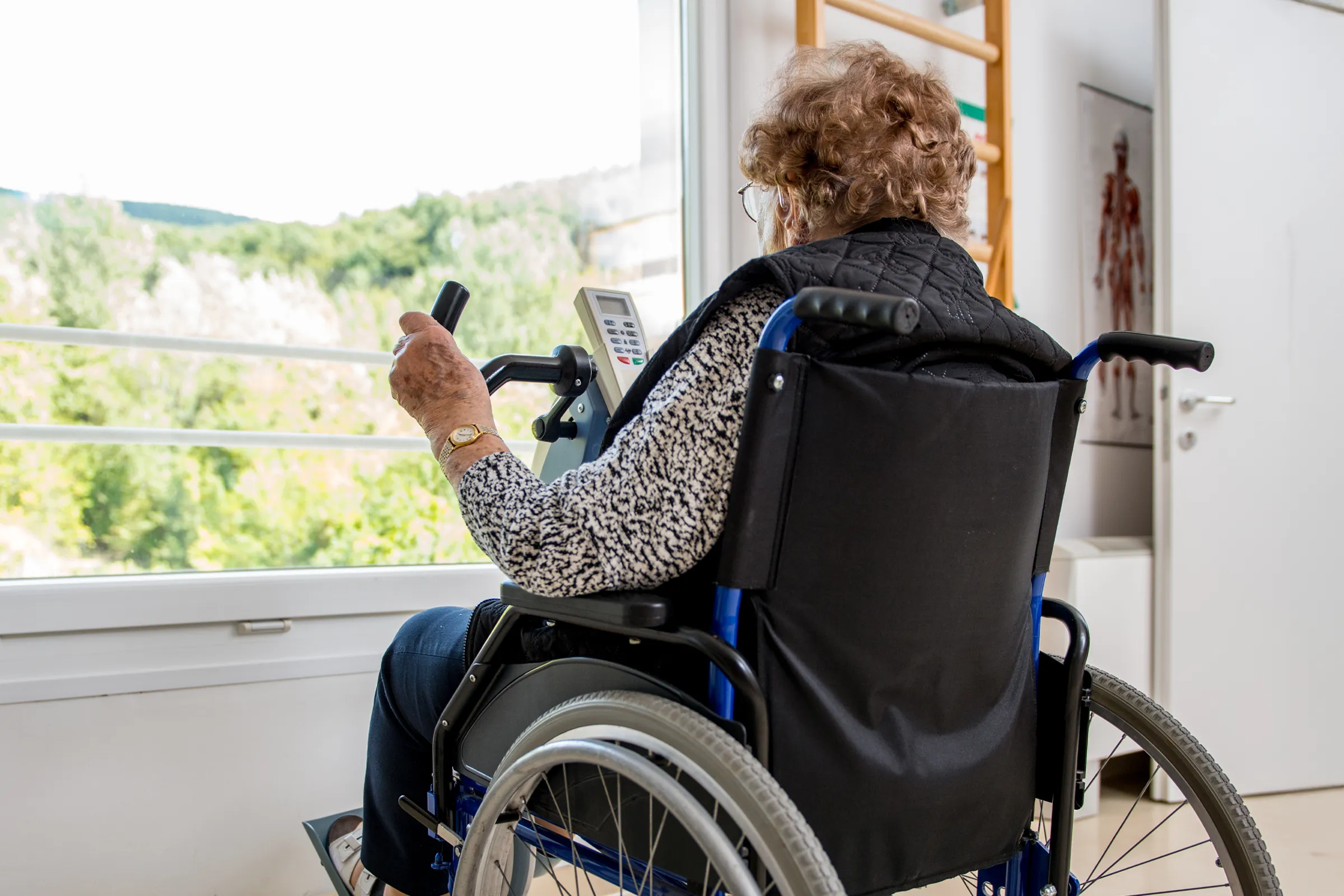 Elderly woman exercising in wheelchair by window